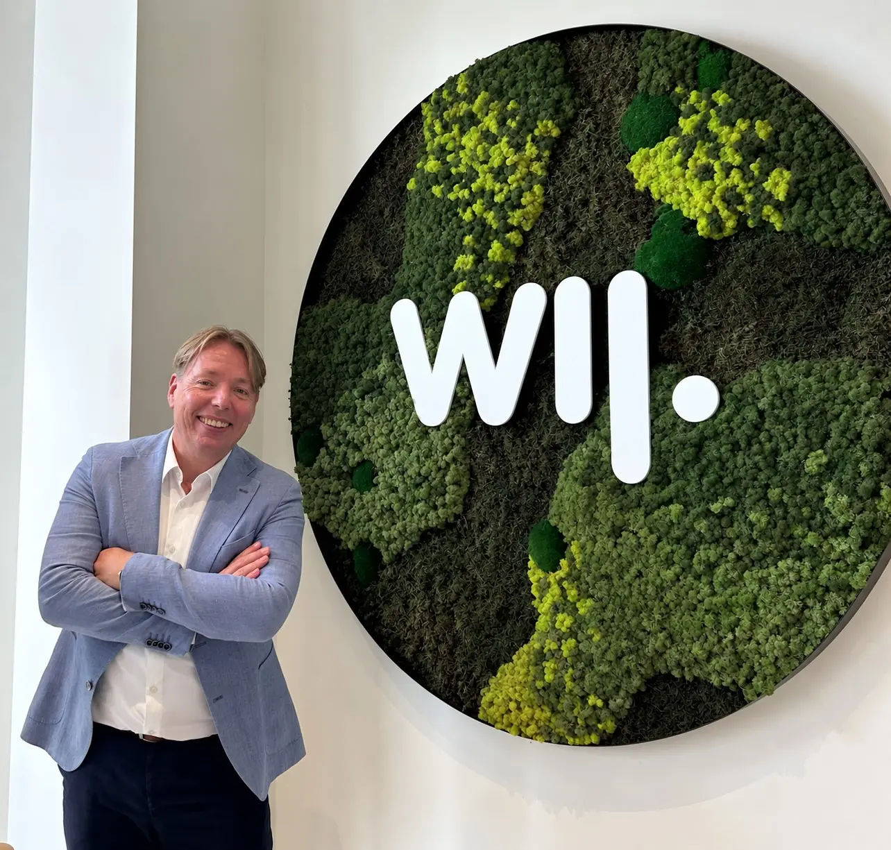Martin Peeringa bij het WIJ-logo op kantoor